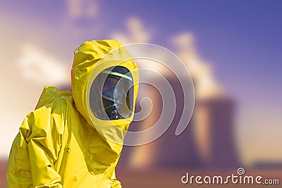 View of smoking coal power plant and men in protective hazmat suit Stock Photo