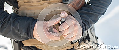 View of soldier hands load gun bullets into cartridge clip Stock Photo