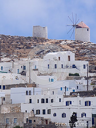 A view of some white houses of Chora of Amorgos, with the windmills above them Stock Photo