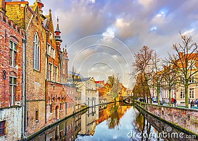 View from Steenhouwersdijk street to typical brick houses along canal, Bruges, Belgium Editorial Stock Photo