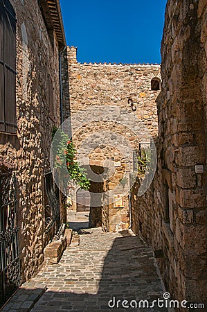 View of stone houses in a narrow alley under blue sky at Les Arcs-sur-Argens at Les Arcs-sur-Argens Editorial Stock Photo