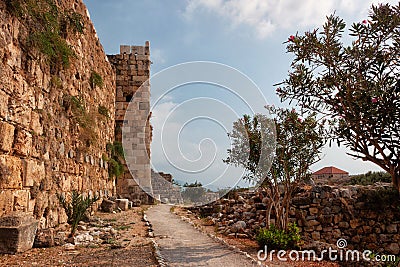 View of the stone wall of the old ancient crusader castle in the historic city of Byblos. The city is a UNESCO World Heritage Site Editorial Stock Photo