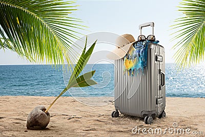 Suitcase with hat, pareo and sunglasses on sunny tropic beach Stock Photo