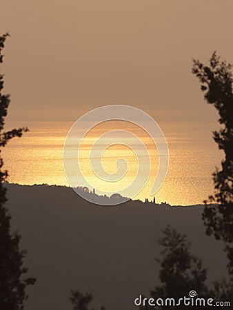 View of a sunset enclosed in a frame of trees Stock Photo