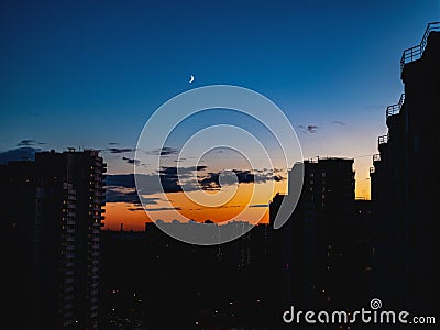 The view on the sunset and the moon in the suburb, urbanistic landscape. Stock Photo