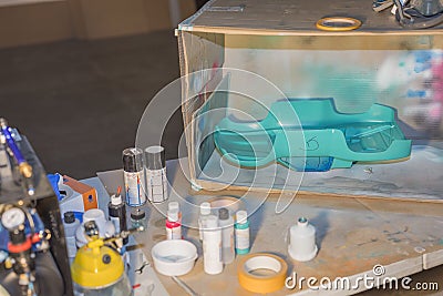 View of table with hand made box for painting of small plastic objects with spray color Stock Photo