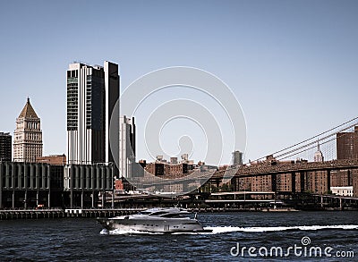 View of tall buildings in New York City with a yacht travelling across the river Editorial Stock Photo