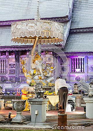 Thai man praying and making an offering before Ganesha statue at Wat Sri Suphan or Silver Temple, Chiang Mai, Thailand Editorial Stock Photo