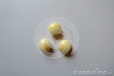 View of 3 round yellow pills of xylitol from above Stock Photo