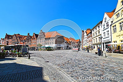 View to the German medieval town of Lueneburg. You see the marketplace with facades of bricks and small shops with tourists Editorial Stock Photo