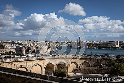 View to Grand Harbour in Valletta, Malta. Road viaduct in foreground, ships moored at the docks. Stock Photo