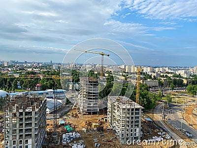 A view to the multistorey apartment building among cottages. Initial stage of multifamily house building in the private sector of Stock Photo