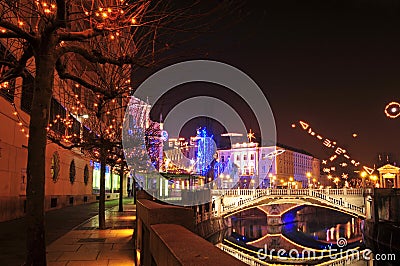 View to one of Three bridges, with Ljubljanica river and decorated trees for Christmas and New Years holiday Stock Photo