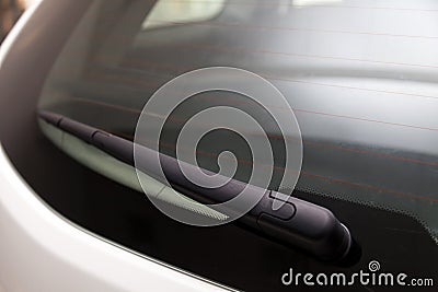 View to the rear window wiper that remove the melted snow and dirt from the windshield of the car during the day during the snow Stock Photo