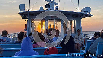 View from on top of a Fire Island Ferry boat heading into the sun setting in the horizon Editorial Stock Photo