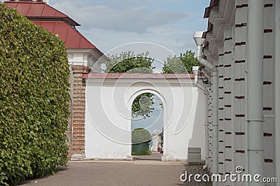 View of the topiary and the sea through the doorway in the white wall. Hidden park. Secret garden. Stock Photo