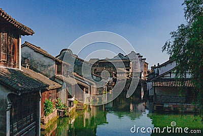 Traditional Chinese houses and bridge by water under blue sky, in the old town of Wuzhen, China Stock Photo