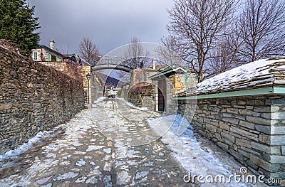 View of traditional stone buildings and streets with snow at the famous village of Nymfaio near Florina. Stock Photo