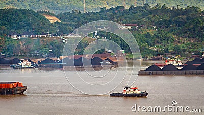 View of traffic of tugboats pulling barge of coal at Mahakam River, Samarinda, Indonesia. Editorial Stock Photo