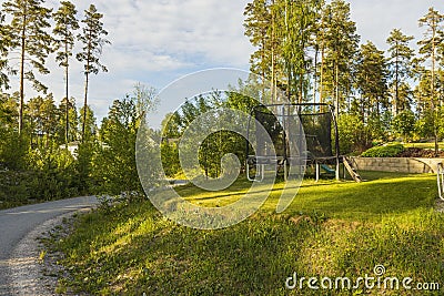 View of of trampoline with safety net mounted on backyards. Stock Photo
