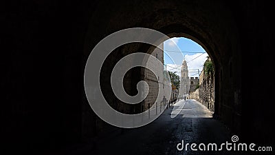 View of a tunnel in the Armenian Patriarchate Street with the Abbey of the Dormition in the background Stock Photo