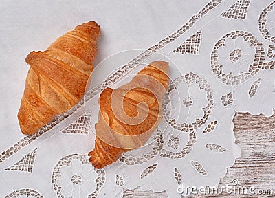 View on two fresh croissants on white vintage richelieu embroidery doily Stock Photo