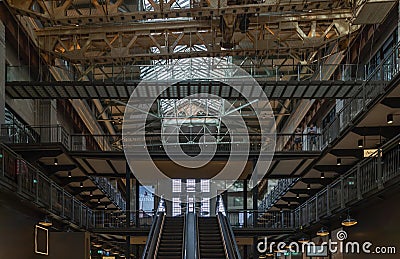 View of Two interior escalators and an old gantry crane suspending an art installation at New Battersea Power Station Editorial Stock Photo