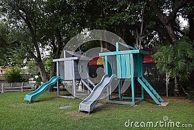 View of two slides in a public park, background grass and trees Stock Photo