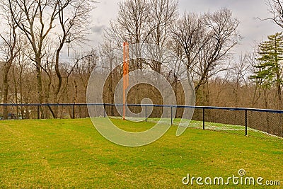 View of typical nondescript high school softball left outfield orange foul pole Stock Photo