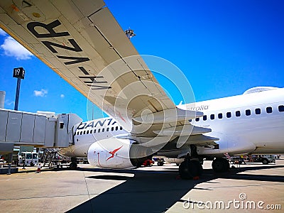 The view under the plane left wing of Qantas domestic airline Aircraft Type: Boeing 737 on the runway. Editorial Stock Photo