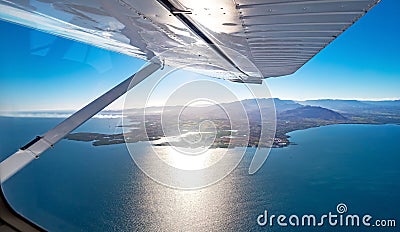 View from under a seaplane wing flying over a paradise island Stock Photo