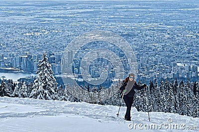 Woman hiking snowshoeing near North Vancouver on Cypress Mountain ski resort in winter. Stock Photo