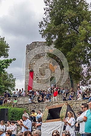 View of various people watching outdoor concert at Vouzela medieval fair, medieval castle as background Editorial Stock Photo