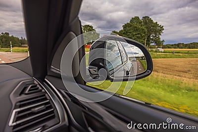 View of vehicle behind in side mirror of moving car. Stock Photo
