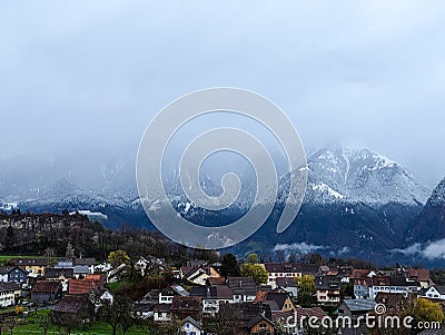 View of the village on the background of mountains. Panoramic view of foggy morning. View from the terrace. Stock Photo