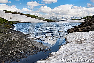 view in water edge of an french alpine lake with peak mountain range background Stock Photo