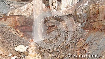 View of waterfall on background of dirty mineral rock. Stock. Dirty waterfall trickle down mineralogical brown rock wall Stock Photo