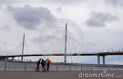 View of the Western Expressway Bridge and the Gulf of Finland. Three young men take pictures against Editorial Stock Photo