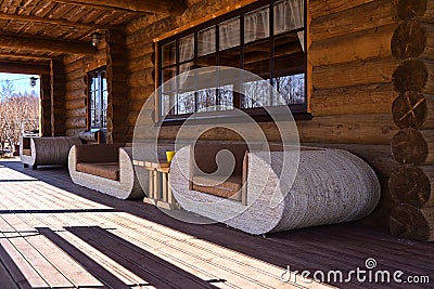 View of white sofas on log house terrace Stock Photo