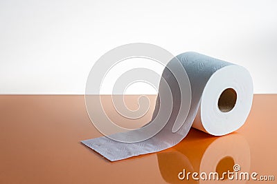 View of a white toilet paper roll over an orange background Stock Photo