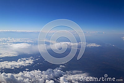 View from the window of the plane to the cumulus clouds and the infinitely blue sky. Stock Photo