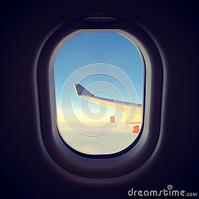 View of wing out plane window, sunset Stock Photo