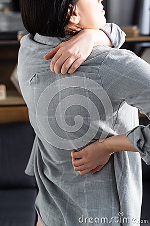 View of woman with allergy scratching back at home Stock Photo