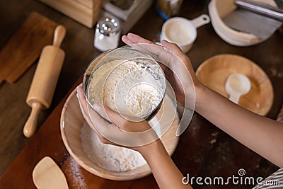 Woman Hand Sifting Bread Flour Before the Process of Kneading Dough Stock Photo