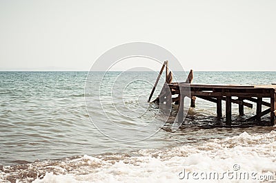 View of a wooden pier and seascape with running waves Stock Photo