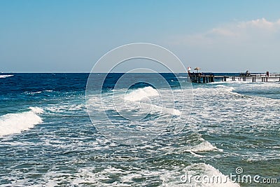 View of a wooden pier on the tropical seashore with blue sky and sea. Stock Photo