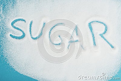 View of word sugar made on sprinkled white sugar crystals on blue surface Stock Photo