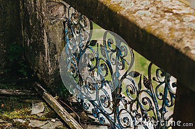 View of the wrought iron decorative bars of the old stone balcony. Abandoned littered area. Ancient architecture Stock Photo