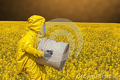 View of yellow field and men in protective hazmat suit Stock Photo