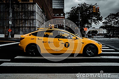 View of yellow Tesla Taxi driving by with the New York urban background Editorial Stock Photo